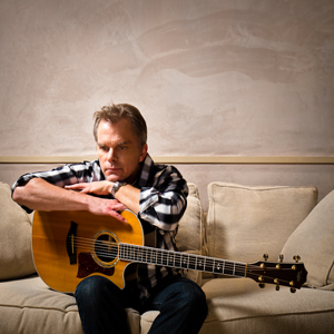 John Defaria seated with his guitar